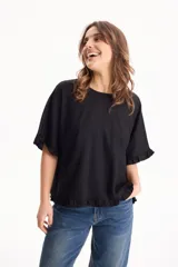 Blusa de lino negra de manga corta con detalles de volados en las mangas y en el ruedo, de diseño holgado y escote redondo.