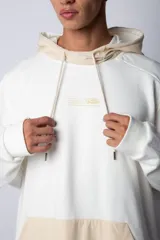 Buzo canguro blanco con capucha forrada en beige y bolsillo tipo parche color beige. Estampa con logo en el pecho.