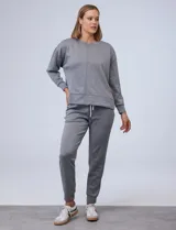 Buzo blanco de tejido elastizado, con pespunte central en la parte delantera y tajos laterales.