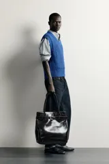 Chaleco de punto trenzado color azul, de corte relaxed fit, con cuello en V y sisas acabadas en rib.