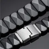 Pulsera de eslabones de acero y cerámica negra con diseño facetado piramidal.
