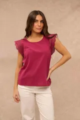 Blusa fucsia sin mangas con cuello redondo y detalles de encaje broderie en los hombros.