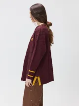 Sweater de cuello redondo con diseño de tejido en relieve de rombos, manga larga y calce holgado. Presenta logo bordado en el pecho y aberturas laterales en el ruedo.