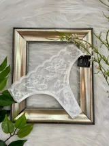 Vedetina clásica confeccionada íntegramente en encaje floral blanco, con bordes festoneados y diseño de cobertura media.