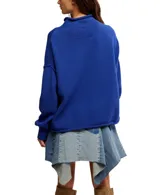 Buzo de tejido punto color beige claro, de calce oversized y cuello alto. Presenta mangas largas con puños anchos y dobladillos enrollados en ruedo y puños.