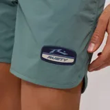 Short de baño Rusty Quijote color verde con cordón ajustable en la cintura y logo de la marca en la pierna derecha.