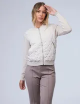 Campera bomber color beige, marca Elie Tahari. El frente es capitoneado con diseño de rombos, la espalda y las mangas son tejidas.
