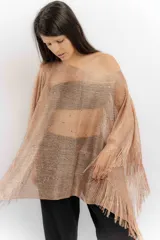 Poncho de tejido de punto metalizado en color dorado, con diseño amplio y flecos en el borde inferior. Presenta apliques sutiles de piedras y un estilo holgado.