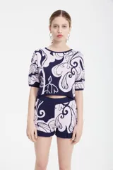 Top tejido en jacquard azul y beige con estampado floral, corto a la cintura, de calce oversize en cuerpo y más entallado en mangas, con escote redondo.