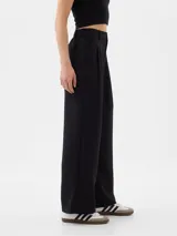 Pantalón de vestir negro de corte recto y tiro alto, con pinzas frontales y bolsillos laterales.