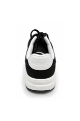 Zapatilla urbana color negro con suela blanca, cordones negros con detalles blancos, y puntera de textura granulada.