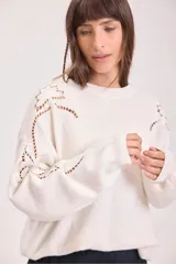 Sweater de punto color negro, de corte holgado y manga larga, con detalle de bordado calado en los hombros y a lo largo de las mangas.