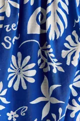 Vestido midi en mezcla de viscosa, de color azul con estampado botánico en tono blanco. Presenta breteles spaghetti con moños para atar, escote cuadrado, canesú ajustado con punto smock en la espalda y falda larga y fruncida con diseño de guardas en el ruedo.