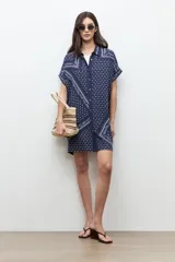 Vestido túnica azul marino con estampado paisley y floral blanco, de corte recto, manga corta y cierre frontal con botones.