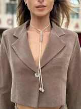 Colgante de gamuza color marrón claro con dije central de strass y terminaciones con dijes esféricos de strass.