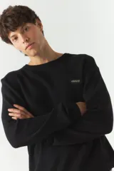 Sweater negro de punto con cuello redondo y puños.