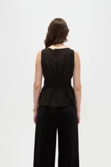 Top de lyocell color negro, sin mangas, con cuello redondo y diseño fruncido con elástico en la cintura que genera un corte peplum.