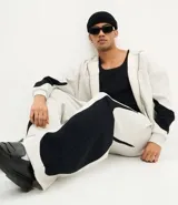 Pantalón de jogging confeccionado en algodón y poliéster, con diseño de paneles laterales en contraste de color negro. Presenta cintura elástica con cordón ajustable y bolsillos laterales.