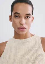 Jersey de punto color crudo, de diseño fluido con cuello redondo, hombros descubiertos y mangas abullonadas.
