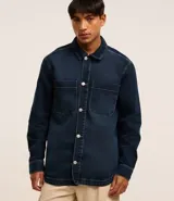 Camisa masculina oversized confeccionada en jeans azul oscuro, con cuello inglés, manga larga, puño ajustado, abotonado delantero y dos bolsillos cargo en el pecho.