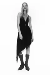 Vestido midi de satén negro con escote en pico y tirantes finos ajustables. Presenta un diseño asimétrico en el bajo con detalle de encaje a tono.