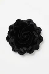 Broche en forma de flor de terciopelo negro con diseño voluminoso en capas.