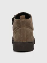 Botín de cuero gamuzado color marrón, con diseño acordonado y suela de poliuretano texturizada. Presenta una caña baja y un estilo casual y versátil.