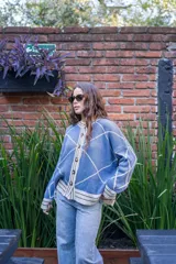 Saco tejido de punto con diseño geométrico de rombos en color azul y blanco. Presenta cuello redondo, cierre frontal con botones, mangas largas abullonadas y terminaciones acanaladas en puños y ruedo.