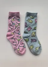 Pack de dos pares de medias de media caña, un par rosa con estampado de chupetines en forma de corazón y un par celeste con estampado de ositos de goma.