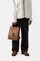 Bolso shopping Carhartt WIP negro de lona de algodón resistente al agua, con asas superiores, correa ajustable y extraíble para el hombro, y estampado gráfico con el logo de la marca en la parte frontal.