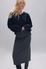 Jersey de punto liso confeccionado en lana 100%, con cuello en pico y manga larga. Presenta acabados en rib en puños y bajo.