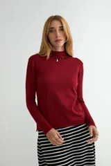 Polera de tejido de punto fino color bordó, con cuello alto y mangas largas.