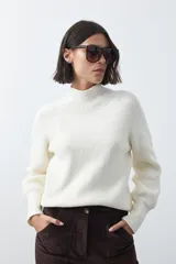 Polera de tejido de punto en color marrón oscuro, con cuello alto y diseño de silueta relajada.