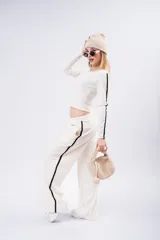 Pantalón tipo palazzo de corte amplio y fluido, color negro, con doble línea lateral blanca y cintura elástica.