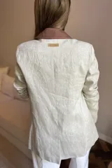 Blazer azul de lino con corte entallado, cuello y solapas combinadas en color gris, cierre con botón de nácar, bolsillos laterales y tajo en la espalda.