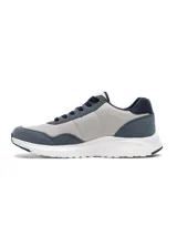 Championes Umbro modelo Volcan para hombre, en tonos de azul y gris claro, con cordones azules y suela blanca. Presentan el logo de Umbro en el lateral.
