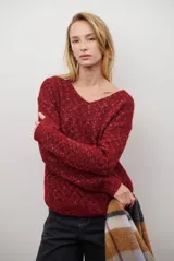 Buzo de punto color bordó con cuello en V, manga larga y diseño de tejido jaspeado.