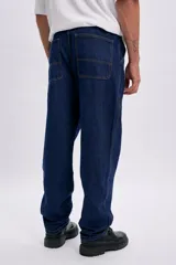 Pantalon de jean de corte carpintero y diseño recto, color azul oscuro, con bolsillos laterales utilitarios.