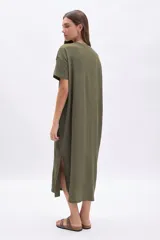 Vestido midi verde con textura, de corte recto y holgado, con cuello redondo y mangas cortas.