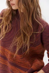 Buzo de punto azul con diseño abstracto en tonos beige.