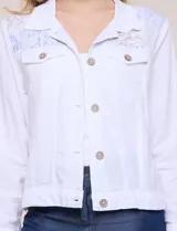 Campera liviana de lino color blanco, con estilo denim y silueta semi entallada. Presenta un canesú superior estampado con motivos florales en tonos azules y tostados, cuello camisero, abotonadura frontal con botones rústicos y bolsillos con solapa en el pecho.