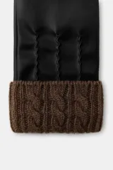 Guantes cortos de efecto piel en color negro, con costuras decorativas en el dorso y puño de tejido de punto trenzado en mezcla de lana color marrón.