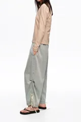 Pantalón jogger de denim celeste claro, confeccionado en mezcla de lyocell y algodón, con tiro bajo, cintura elástica y bajos fruncidos con tiras ajustables.
