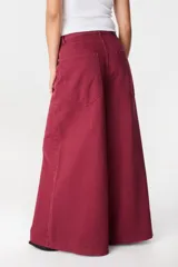 Jean de corte wide leg en color bordó, confeccionado en denim de algodón. Presenta tiro medio, bolsillos traseros amplios y una silueta holgada y fluida.