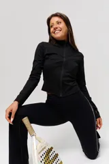 Campera deportiva negra de corte crop, con cierre frontal completo y cuello alto. Confeccionada en tejido técnico elástico, presenta costuras reforzadas que realzan la silueta.