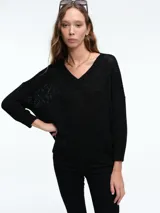 Sweater de tejido de punto con brillo sutil, corte relajado, escote en V y hombros caídos.