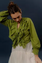 Camisa verde de manga larga, con volados frontales y detalles de puntilla bordada.