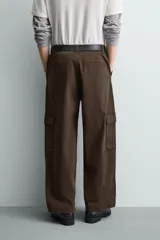 Pantalón cargo de corte relajado confeccionado en tejido de algodón con elasticidad. Presenta bolsillos laterales tipo cargo con solapa en las perneras, bolsillos frontales y bolsillos traseros de doble vivo. Cierre frontal con cremallera y botón.