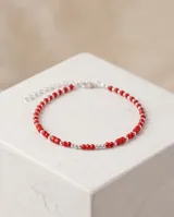 Pulsera de plata 925 con cuentas facetadas de cristal rojo y pequeñas esferas plateadas intercaladas, con cierre de mosquetón y cadena de alargue.