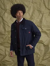 Campera de gabardina color azul marino, con cuello camisero, cierre frontal con botones metálicos y bolsillos frontales con solapa.